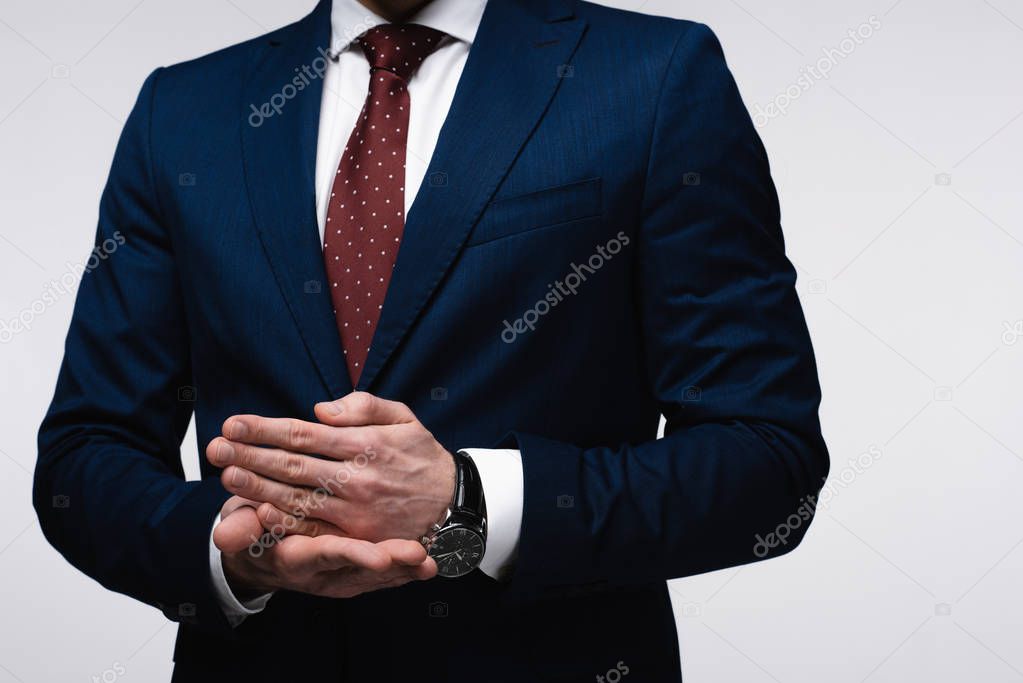 partial view of confident businessman gesturing with hands isolated on grey, human emotion and expression concept
