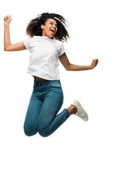cheerful african american woman gesturing while celebrating and jumping isolated on white  clipart