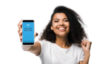 Kiev, Ukrayna - 29 Mayıs 2019: skype uygulaması ile akıllı telefon tutan ve beyaz izole kutluyor mutlu Afrikalı Amerikalı kız seçici odak 