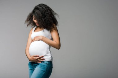 gri ayakta iken göbek dokunmadan mutlu hamile afrikalı-amerikalı kız 