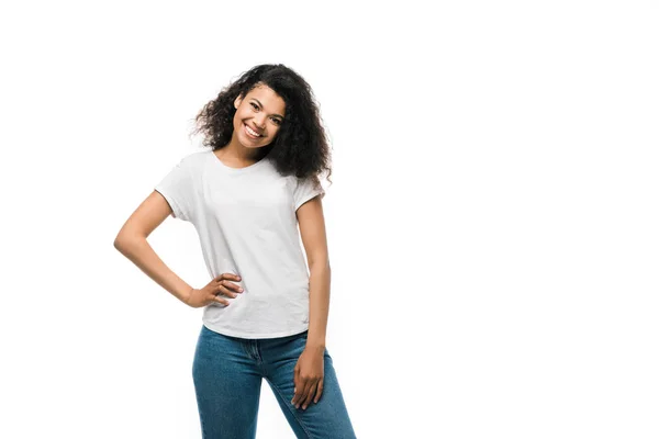 白いTシャツを着た幸せなアフリカ系アメリカ人の女の子が 白で孤立した腰に手を当てて立っている — ストック写真