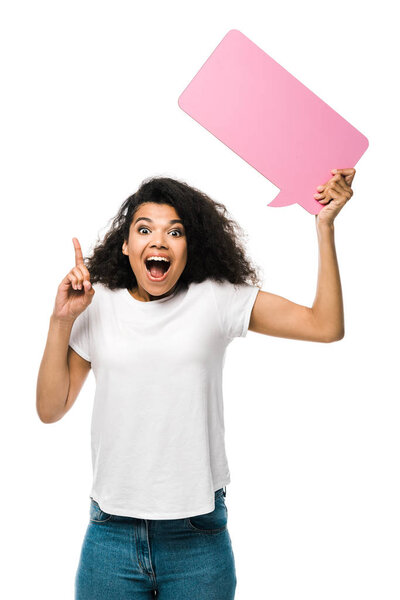 cheerful african american girl holding pink speech bubble and pointing with finger isolated on white 