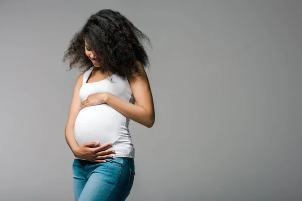 Feliz Embarazada Africana Americana Chica Tocando Vientre Mientras Pie Gris — Foto de Stock