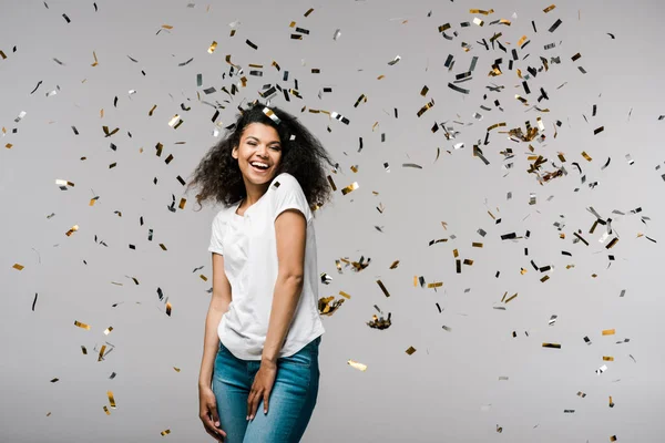 Feliz Joven Afroamericana Mujer Sonriendo Cerca Brillante Confeti Mientras Pie —  Fotos de Stock