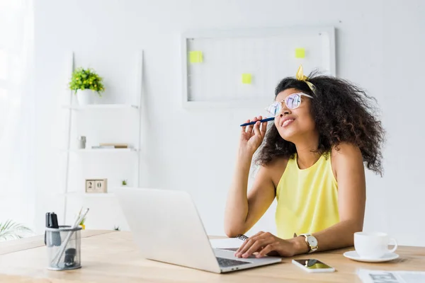 Thoughtful African American Woman Glasses Holding Pen While Sitting Laptop — Stock Photo, Image