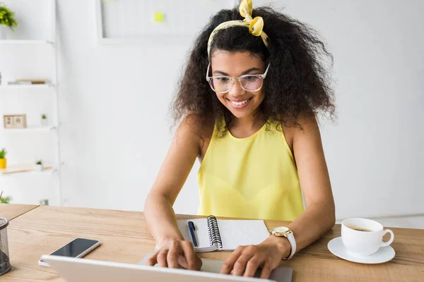 Mulher Americana Africana Feliz Óculos Usando Laptop Perto Xícara Café — Fotografia de Stock