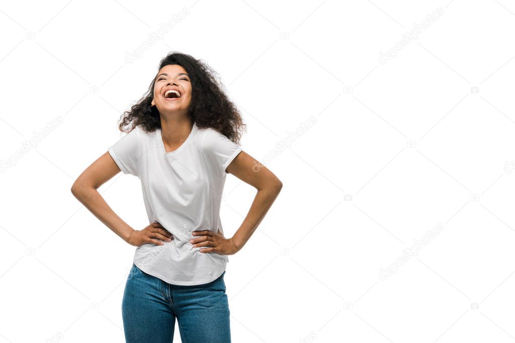 happy african american woman laughing and standing with hands on hips isolated on white 
