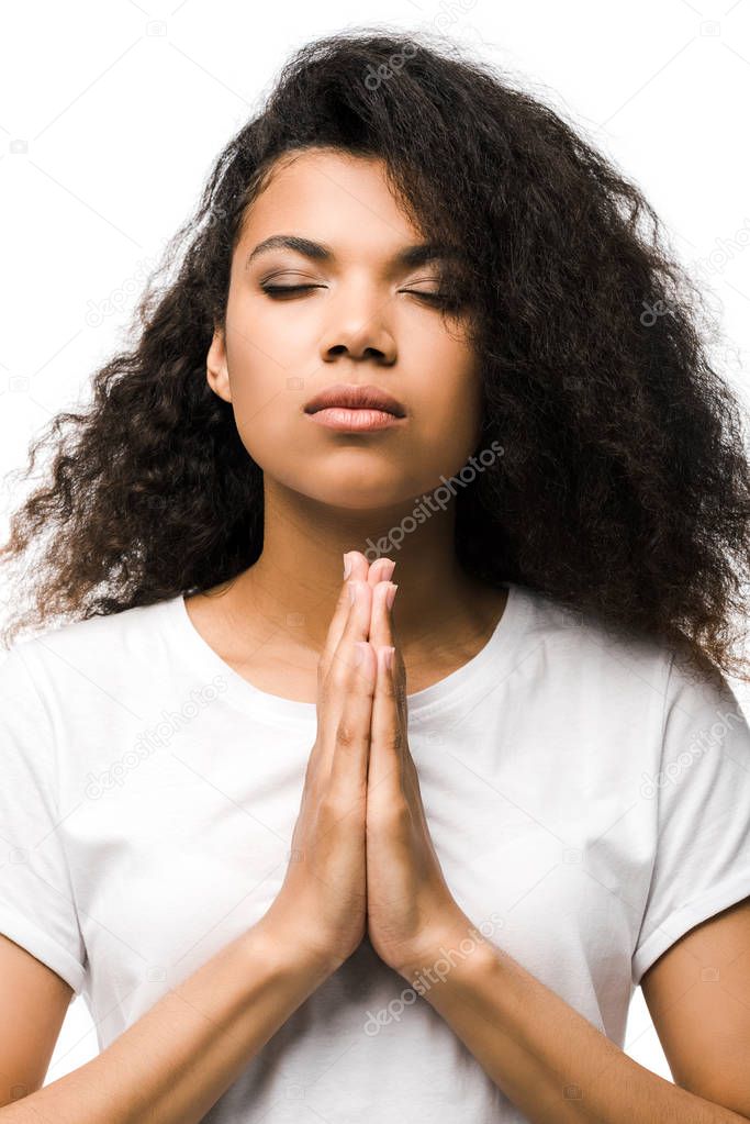  young african american woman with closed eyes and praying hands isolated on white 