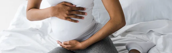 Tiro Panorâmico Mulher Americana Africana Grávida Tocando Barriga Enquanto Sentado — Fotografia de Stock