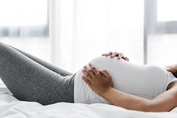 Vista Ritagliata Donna Africana Americana Incinta Toccare Pancia Mentre Sdraiato — Foto Stock