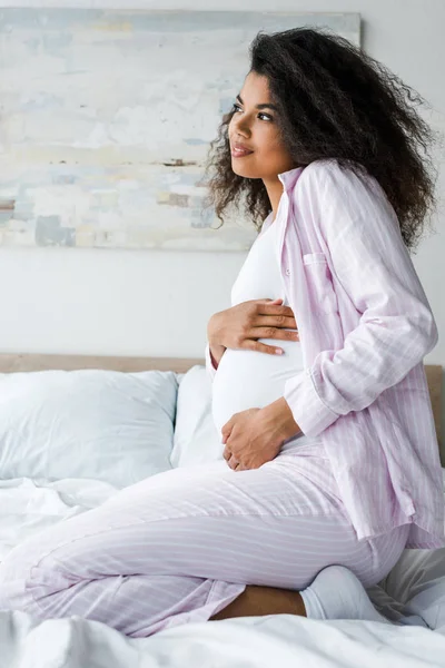 Yatakta Oturan Pozitif Genç Hamile Afrikalı Amerikalı Kadın — Stok fotoğraf