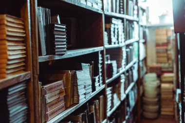 selective focus of retro books on wooden shelves in library  clipart