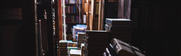 panoramic shot of vintage books on shelves in library 
