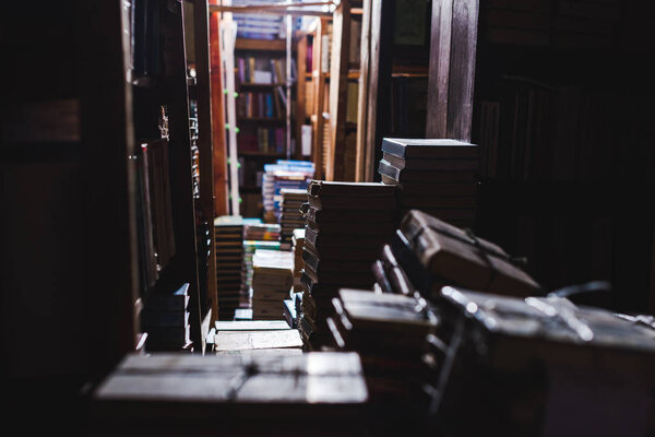 selective focus of vintage books on shelves in library 