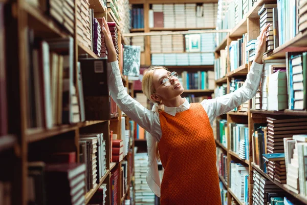 Pretty Blonde Woman Glasses Orange Dress Looking Away Library — Stock Photo, Image