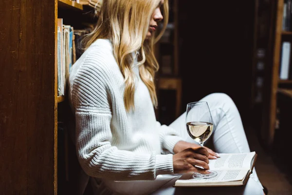 Sarışın Kadın Kitap Okuma Kütüphanede Cam Şarap Tutan Yan Görünümü — Stok fotoğraf