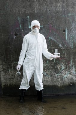 nehirde su örnekleri ile test tüpleri ve şişe tutan koruyucu kostüm ve solunum cihazı su denetçisi tam uzunlukta görünümü