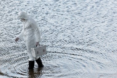 nehirde denetim kiti tutan koruyucu kostüm su denetçisi tam uzunlukta görünümü