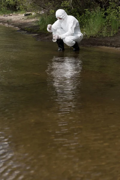 保護衣装 ラテックス手袋 人工呼吸器の水検査官が川で水サンプルを採取 — ストック写真