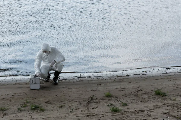 Wasserinspektor Schutzanzug Und Atemschutzmaske Mit Kontrollsatz Sitzt Der Flussküste — Stockfoto