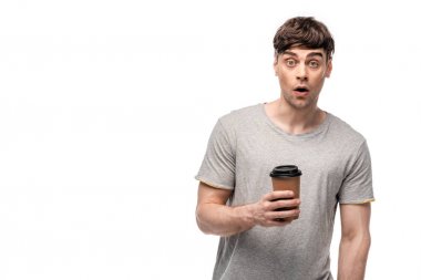 surprised young man looking at camera while holding coffee to go isolated on white clipart
