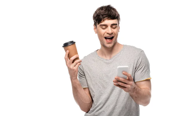 Cheerful Young Man Holding Coffee While Using Smartphone Isolated White — Stock Photo, Image