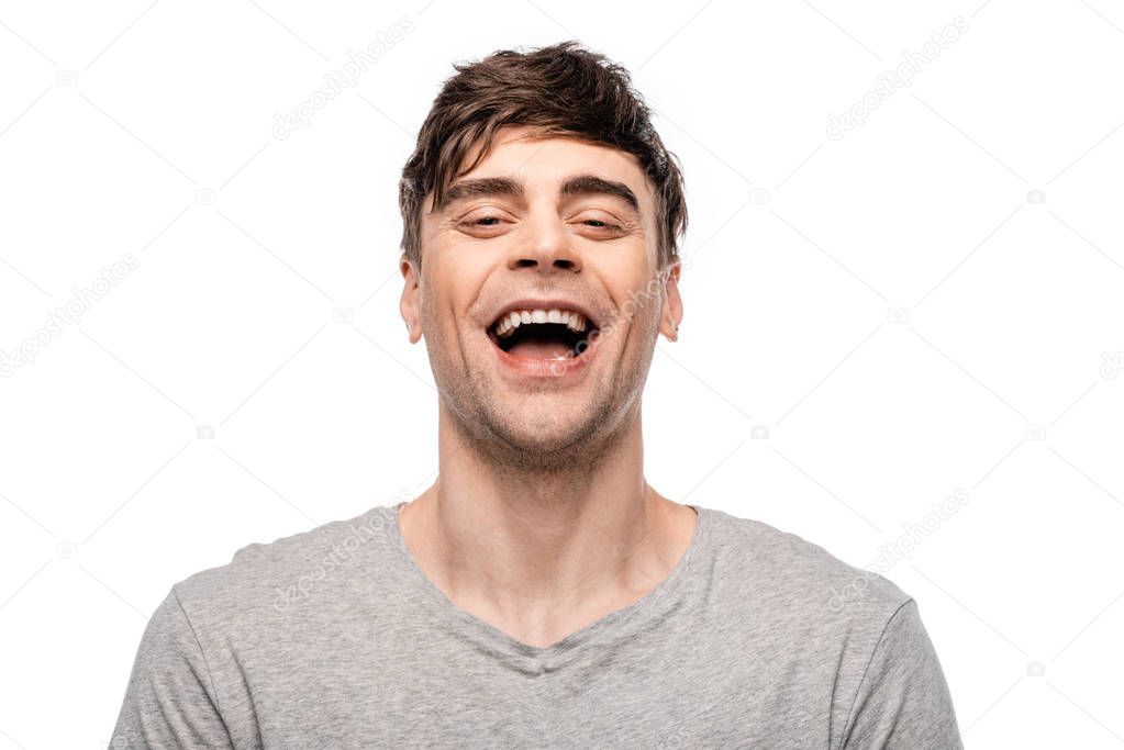 cheerful young man laughing while looking at camera isolated on white