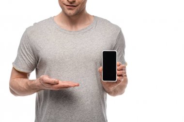 partial view of man in grey t-shirt showing smartphone with blank screen isolated on white