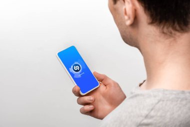 Kiev, Ukrayna - 16 Mayıs 2019: shazam uygulaması ile akıllı telefon kullanan adamın kırpılmış görünümü, gri izole