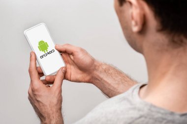 Kiev, Ukrayna - 16 Mayıs 2019: gri izole android uygulaması ile akıllı telefon kullanarak adam kırpılmış görünümü