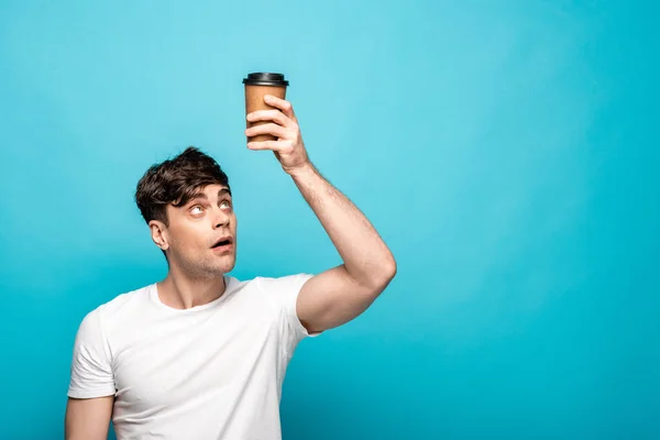Surprised Young Man Looking Disposable Cup Blue Background — Stock Photo, Image