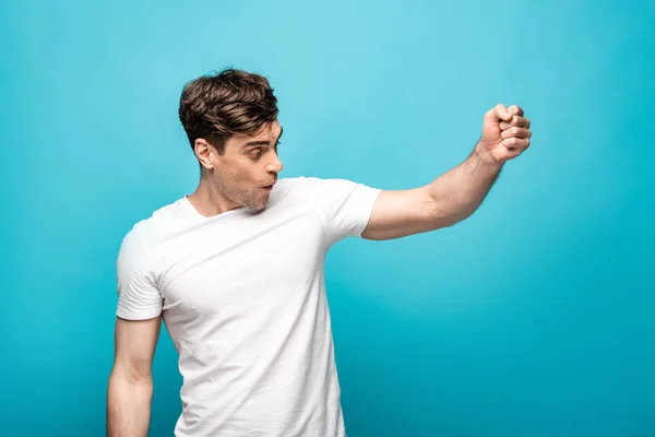 Surprised Young Man White Shirt Showing Fist Blue Background — Stock Photo, Image