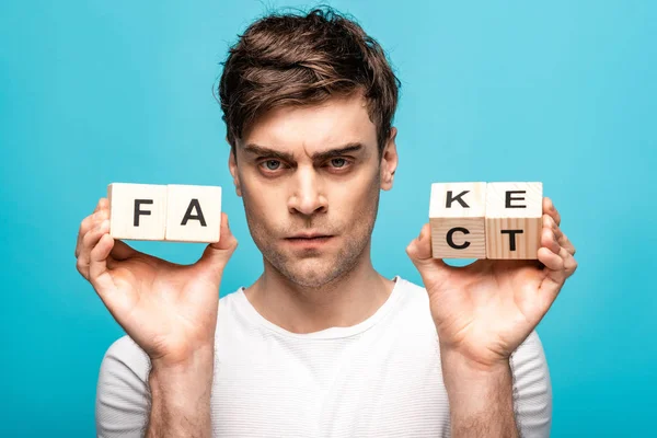 Angry Man Showing Wooden Cubes Fake Fact Lettering Looking Camera — Stock Photo, Image