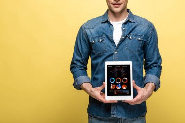 infografik uygulama ile dijital tablet tutan denim giysiler içinde adam kırpılmış görünümü, sarı izole