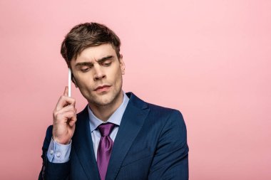 pembe izole akıllı telefon üzerinde konuşurken resmi giyim düşünceli işadamı