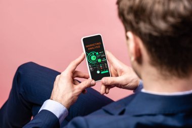 pazarlama analizi ile akıllı telefon kullanarak işadamı kırpılmış görünümü, pembe izole