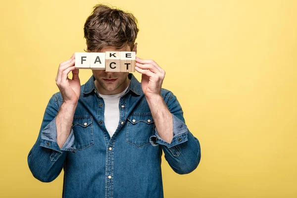 Young Man Denim Shirt Showing Wooden Cubes Fake Fact Lettering — Stock Photo, Image