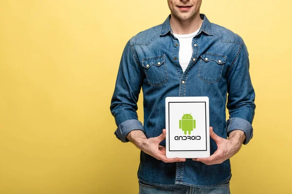 乌克兰 2019年5月16日 裁剪看男人在牛仔裤衣服显示数字平板电脑与Android应用程序 隔离在黄色 — 图库照片