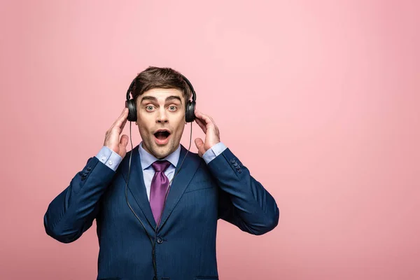 Meglepett Üzletember Nézi Kamerát Miközben Hallgat Zenét Fülhallgató Izolált Rózsaszín — Stock Fotó