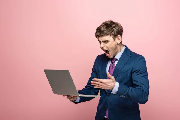 Сердитый Бизнесмен Ссорится Глядя Ноутбук Изолирован Розовый — стоковое фото