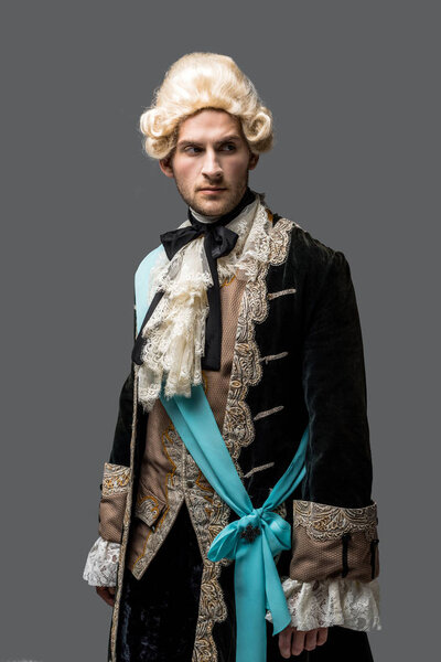 Красивый викторианский джентльмен в парике, изолированный от серых
