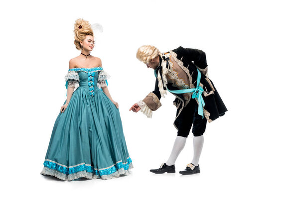 Красивый джентльмен поклоняется рядом с Викторианской женщиной в синем платье, изолированном на белом
  