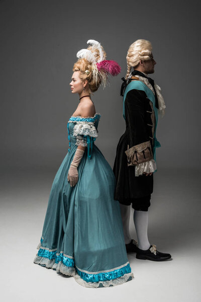 аристократическая женщина и мужчина в викторианской одежде стоят спиной к спине
 