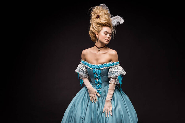 привлекательная викторианка в парике стоящая и трогательная синее платье на черном
 