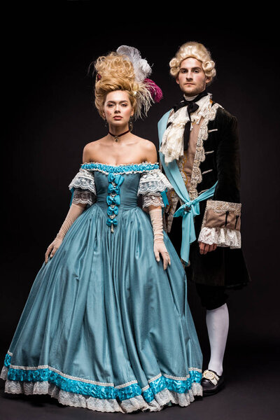красивый викторианский мужчина и женщина в париках, стоящие на черном
 