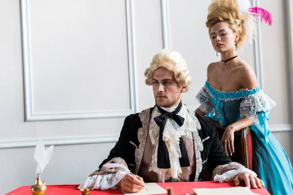 Aantrekkelijke Victoriaanse Vrouw Staande Buurt Van Pompeuze Man Holding Feather — Stockfoto