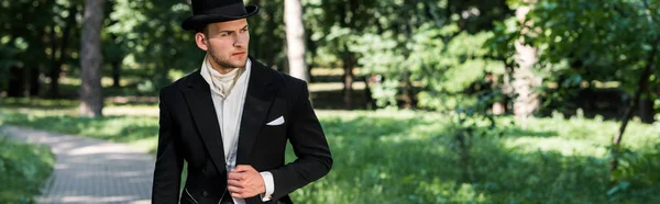 外に立つ帽子をかぶったハンサムなビクトリア朝の男のパノラマショット — ストック写真