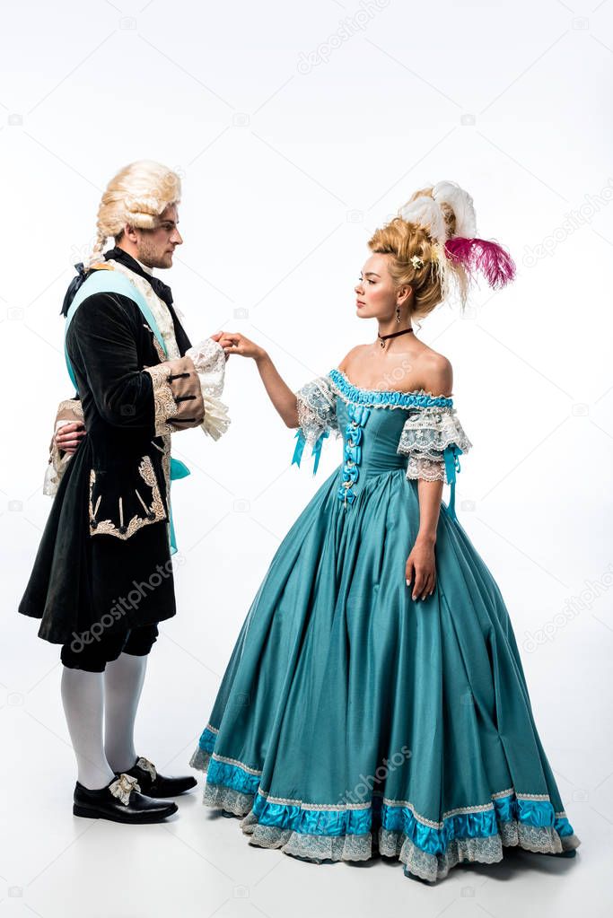 handsome gentleman holding hands with pompous victorian woman in blue dress isolated on white  