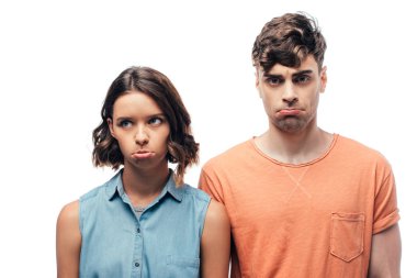 upset man and woman grimacing while posing at camera isolated on white clipart