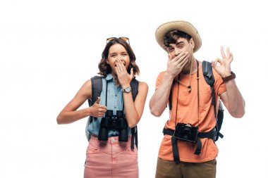 beyaz izole kamera bakarken iki neşeli turist başparmak ve ok işareti gösteren